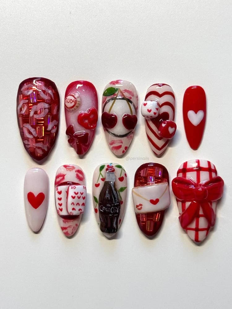 A flat-lay of ten handmade press-on nails in red and white, with sculpted hearts, a bow, a soda bottle and love-letter details.